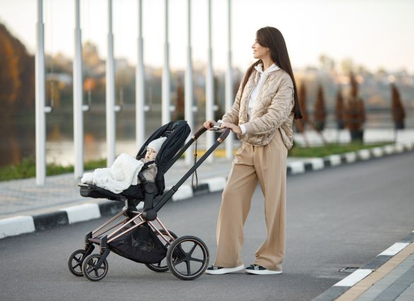 Žena gura dječja kolica s bebom
