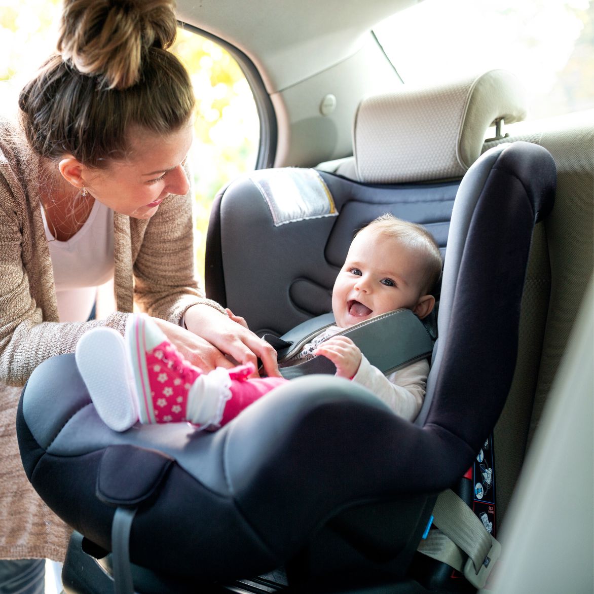 mama stavlja dijete u autosjedalicu